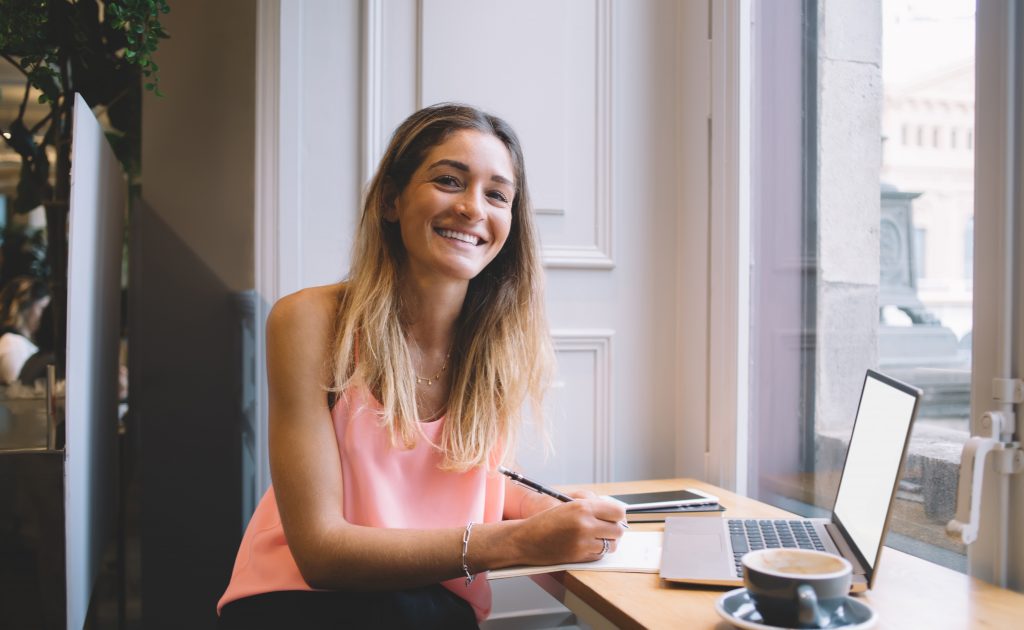 Non-attachment-happy young woman writing at desk