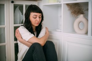 Inner child-woman hugging self in corner